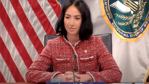 A woman sits at a dias.