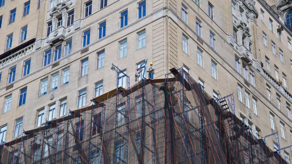 Scaffold workmen on high rise facade