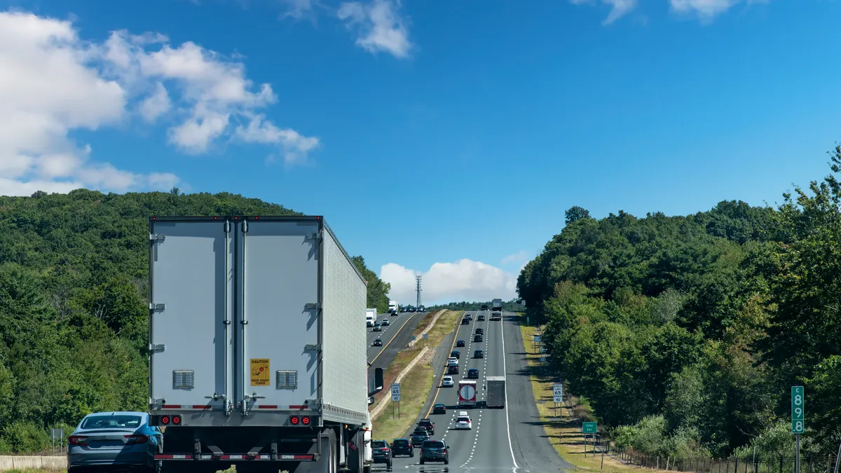 A busy and hilly section shot of Interstate 84 near Willington, Connecticut, with trucks and cars on the highway