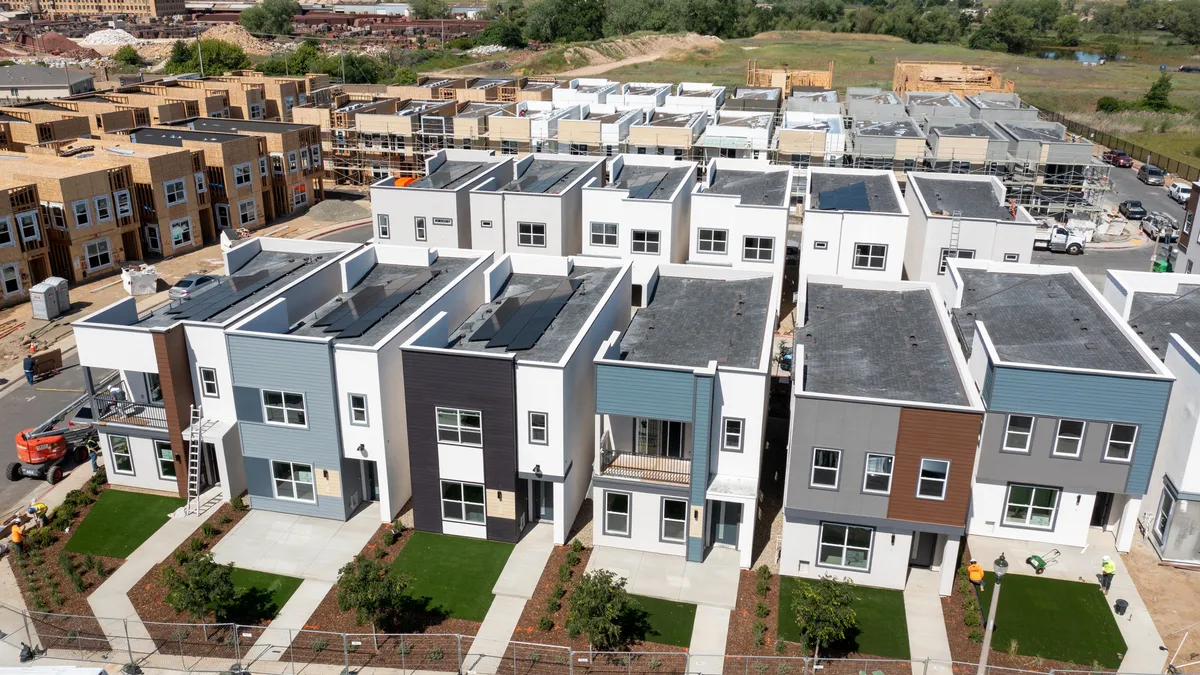 Several rows of rectangular homes - some complete, some under construction.