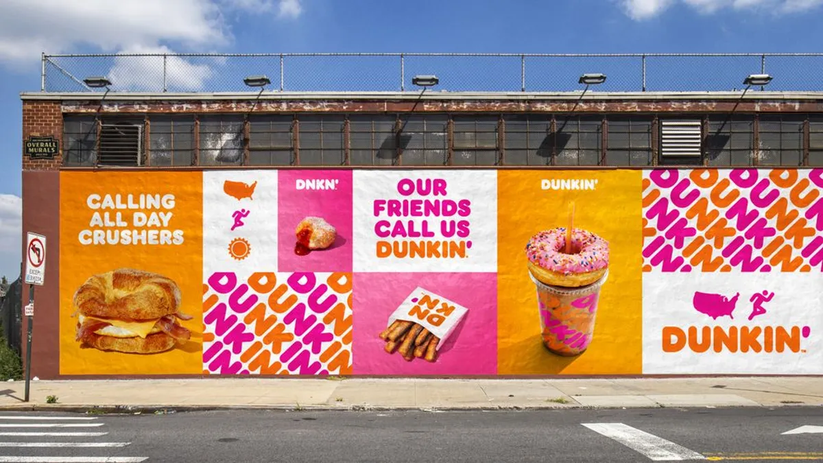 An image showing some of Dunkin's branding pasted on the side of a building.