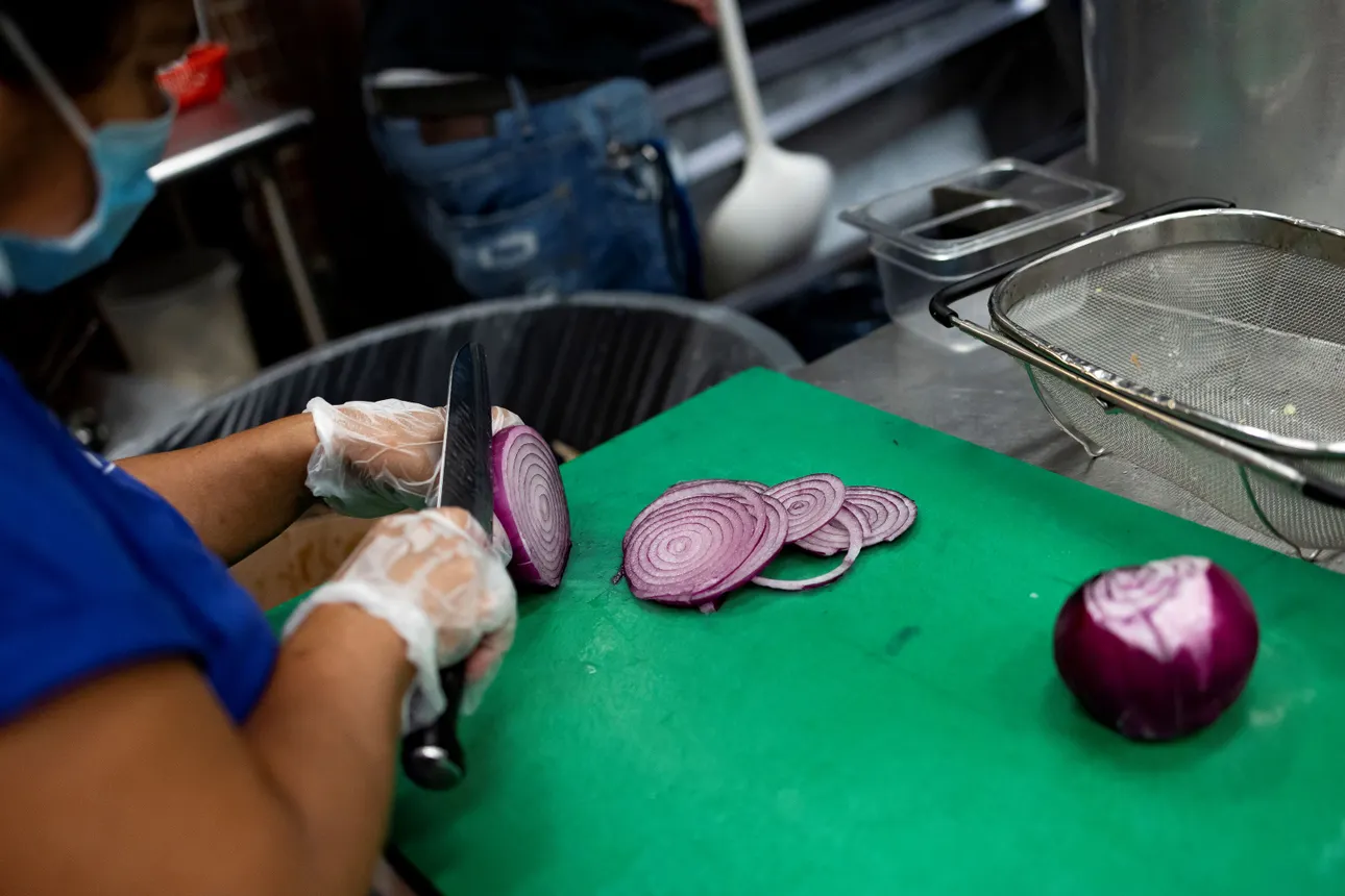 A cook cuts onions in the kitchen at Ben&#x27;s Chili Bowl on August 22, 2022 in Washington, DC.