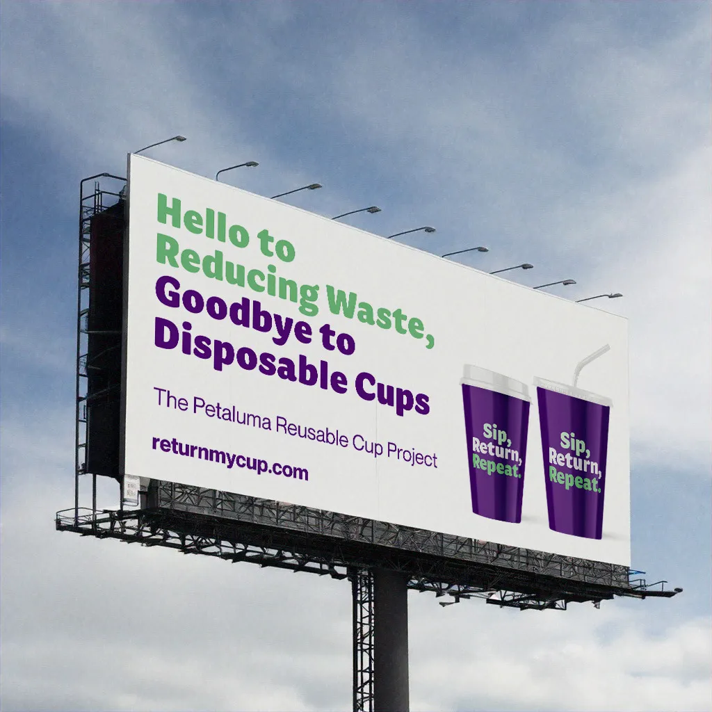 A mockup of a white billboard against the sky that reads &quot;Hello to Reducing Waste, Goodbye to Disposable Cups.&quot; with pictures of two purple cups.