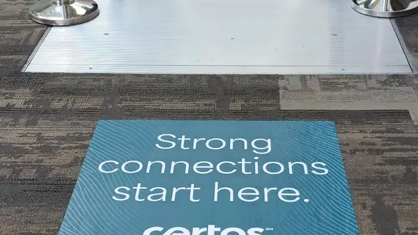 Certos sign attached to carpet in front of escalator.