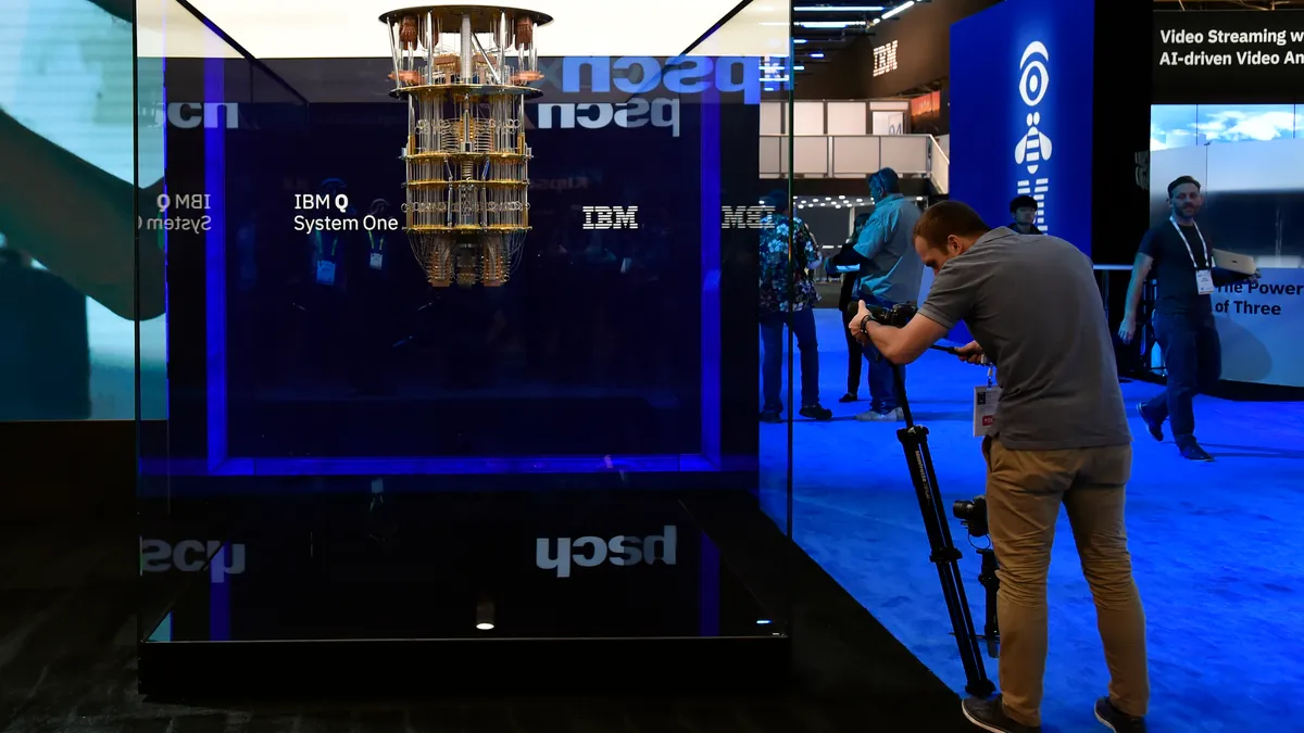 A person takes a photo of a display at a trade show.