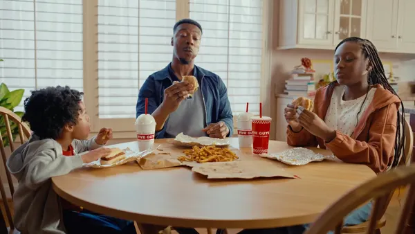 A family eats Five Guys food at home