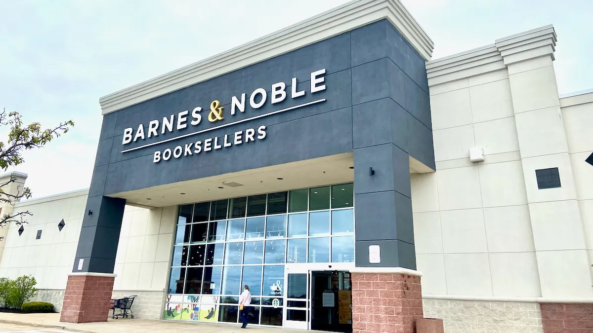 A person walking past a bookstore.