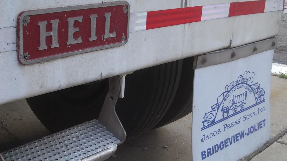 A HEIL decal on the back of a truck, which also has a mudflap that reads "Jacob Press Sons' Inc., Bridgeview-Joliet"