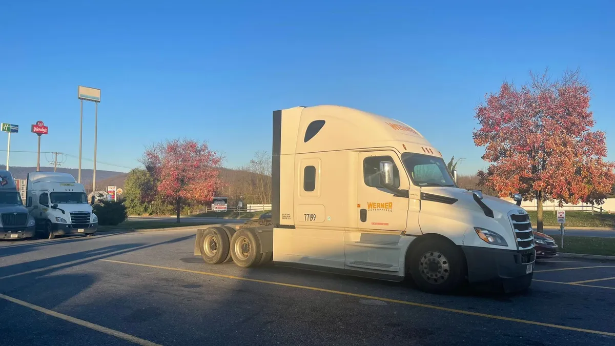 A Werner tractor at a gas station parking lot.