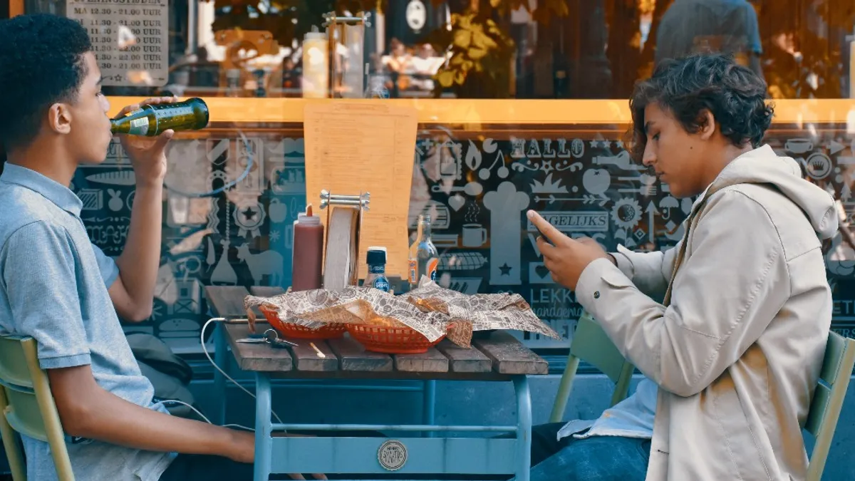 Two teenage boys eating at a restaurant