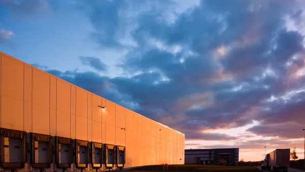 External shot of warehouse with clouds in the background.