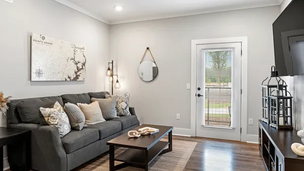 A room with a couch and a door with a window leading outside.