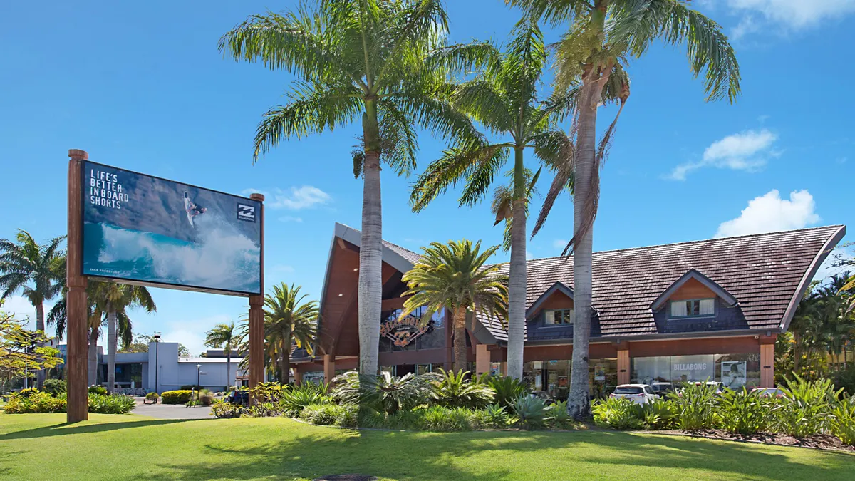 A Billabong store as seen from the outside. Palm trees stand on the grounds.
