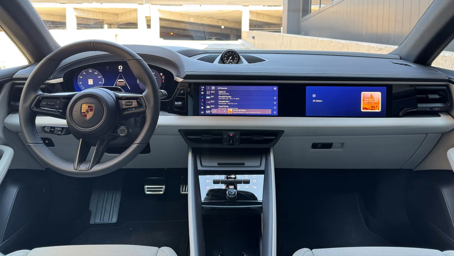 The interior of a 2026 Porsche Macan 4S electric. Three screens run across the dash and a Head-Up Display delivers additional information
