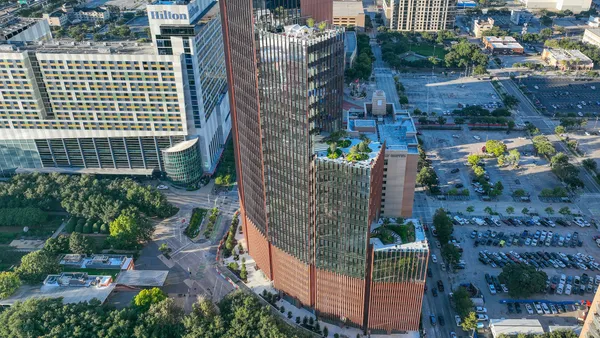 A tall cluster of connected glass buildings descending in height from each structure.