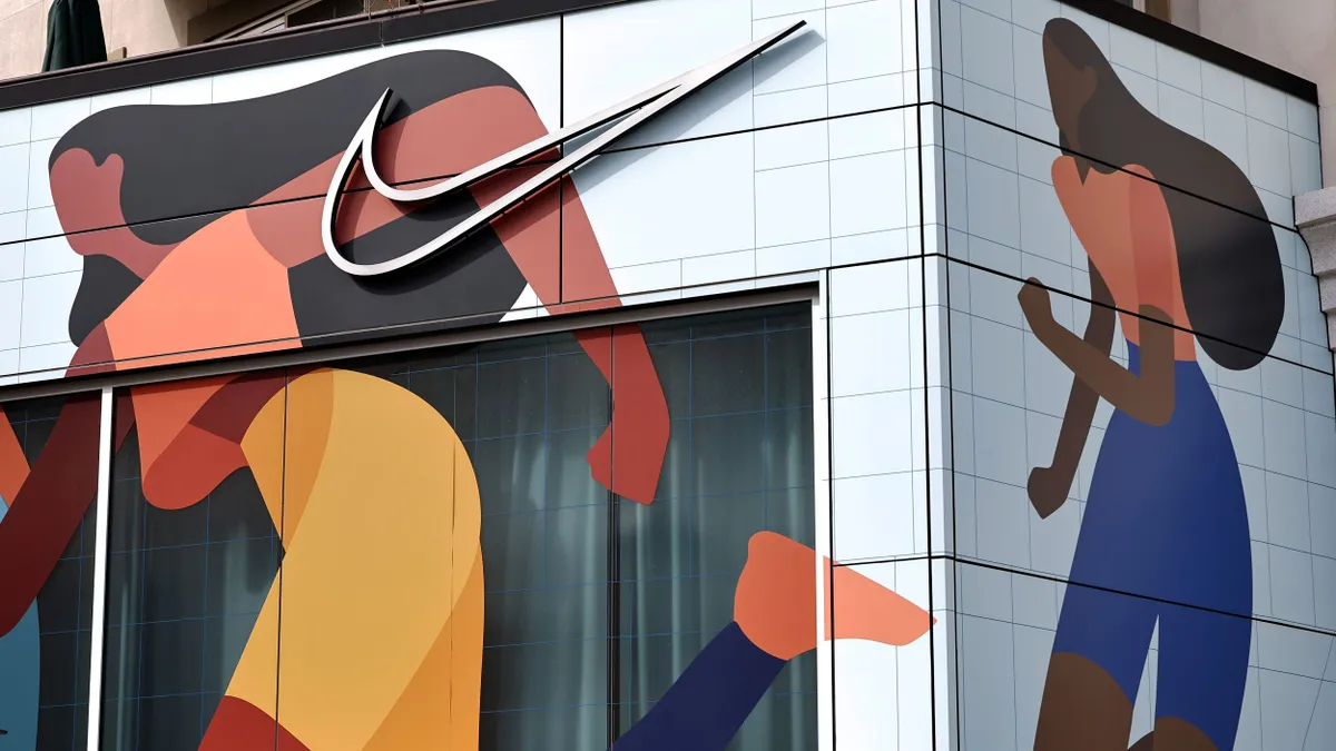 A closeup of a Nike store, showcasing the Nike logo with cartoons of people running.