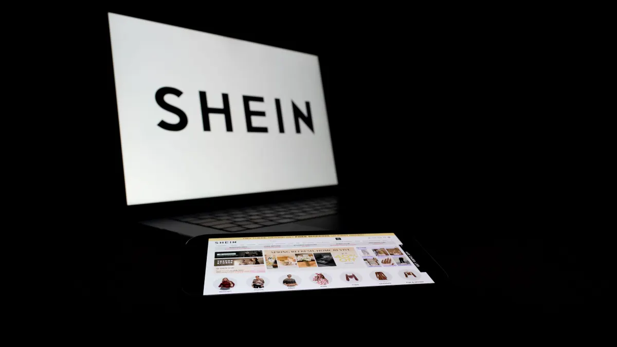 A Shein logo displayed on a laptop against a dark background.