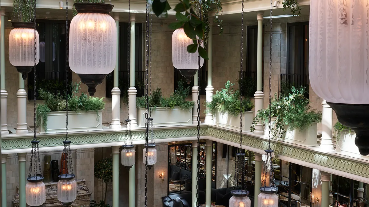 The atrium of NoMad London features hanging plants.