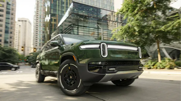 A Rivian R1S vehicle driving in an urban setting