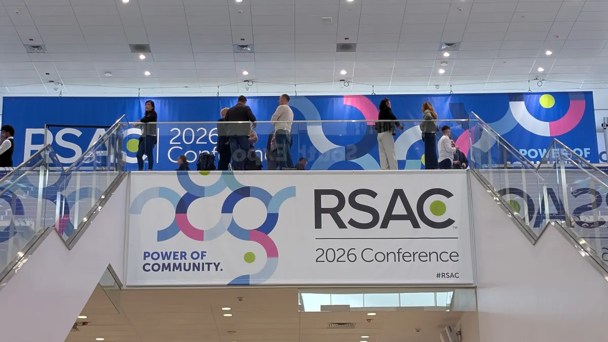 A banner reading "Power of Community" and "RSAC 2026 Conference" hangs over a walkway between two sets of escalators