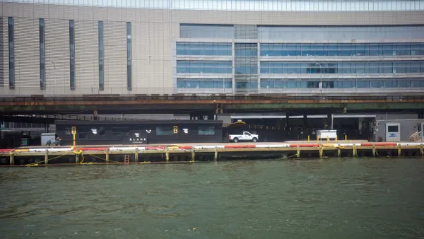 A low building marked "Blade" on a low pier with water in the foreground and a taller building behind.