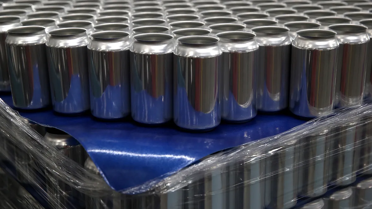 Stacks of empty aluminum cans sit on a pallet.