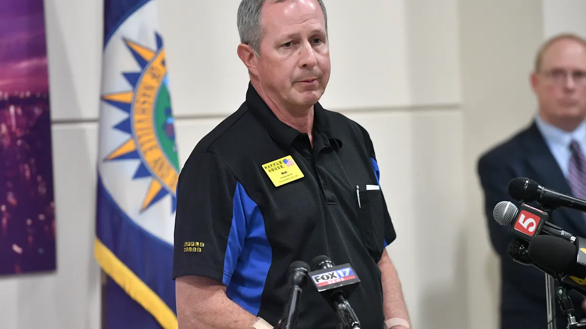 A man with a worn expression addresses a press conference.