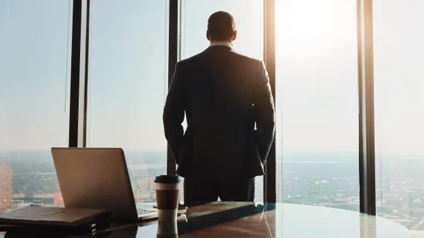 Businessman staring out window in executive office