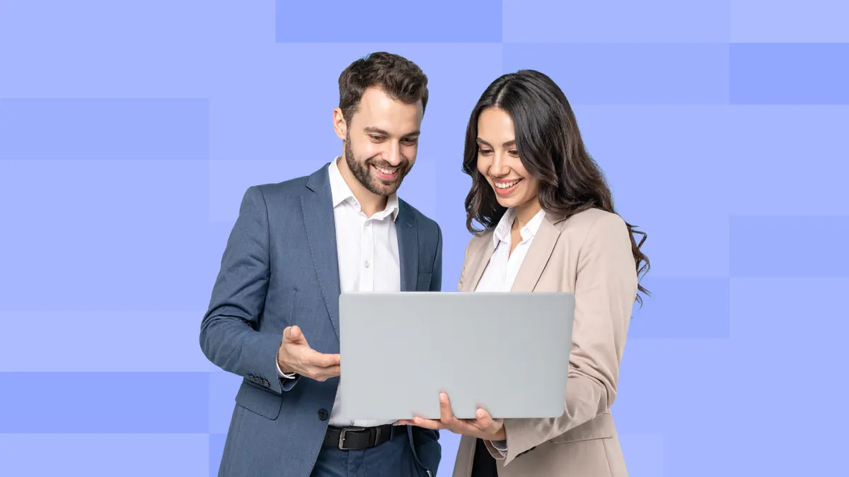 A man and woman in business attire are collaborating while looking at a laptop screen.