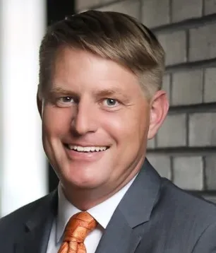 Man in grey suit and orange tie.