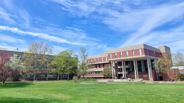 Red brick library sits behind green lawn.
