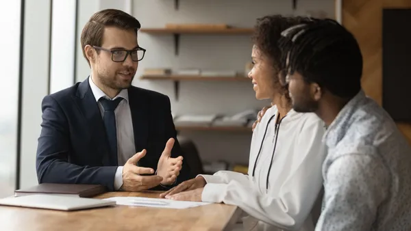 A couple talking to a banker at a table