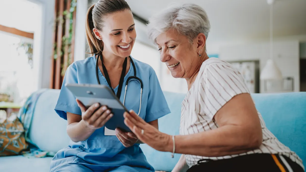 Nurse talking to a senior woman using a tablet