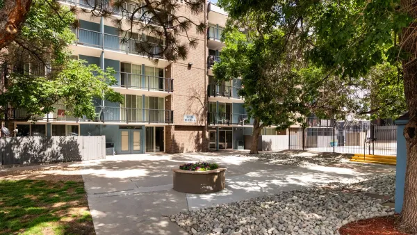 white apartments with tress and gravel in the foreground