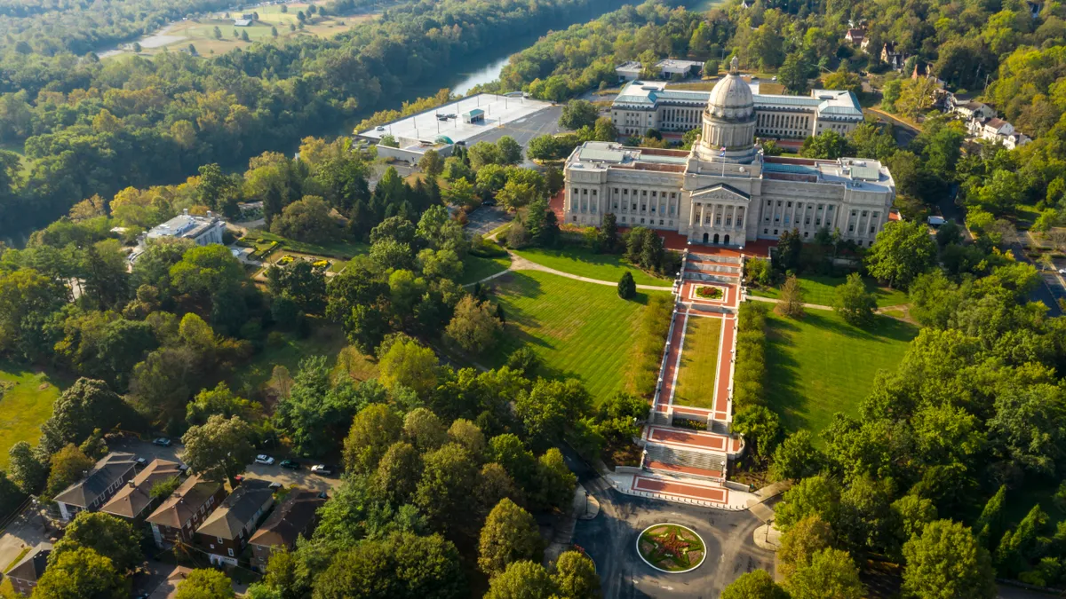 An aerial view of a large white domed building on a summer day.