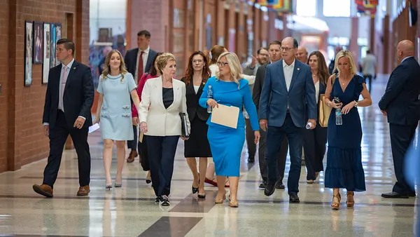 A group of people are walking down a hallway in a school.