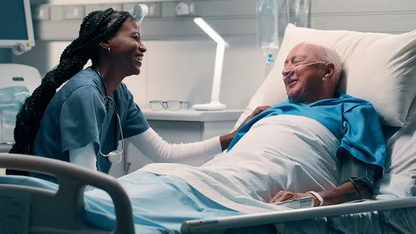 Bed, nurse and smile with patient in hospital for help, support and good news with care.