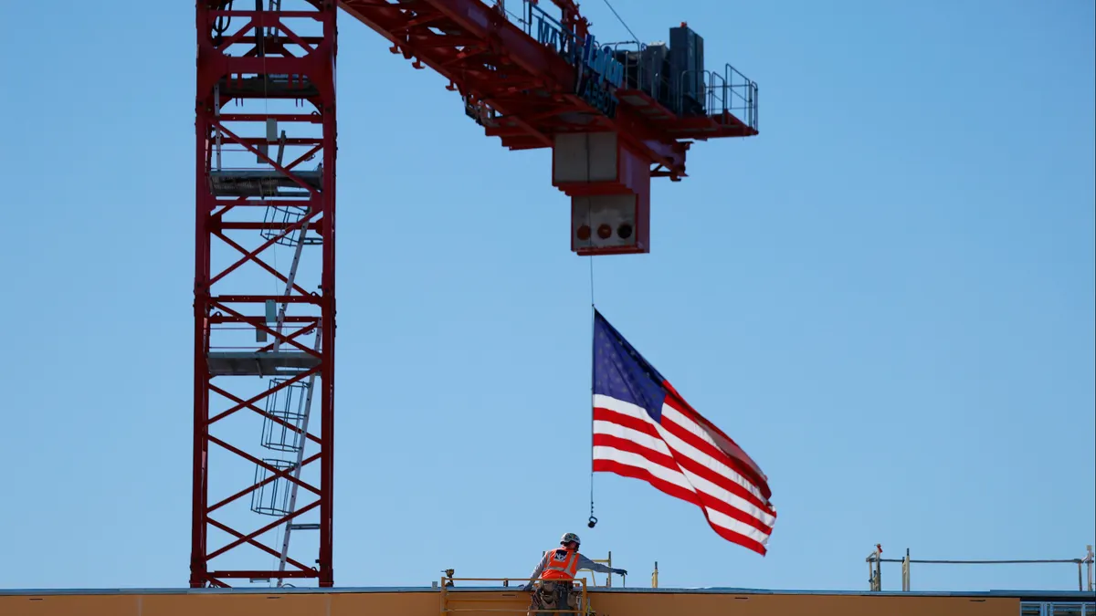 American flag flies from a crane during construction