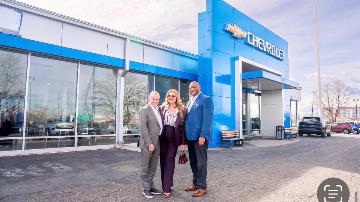 Mike Drawe and Ivette Dominguez Drawe stand with Curtis Harris of GM Financial, at Alpine Chevrolet.
