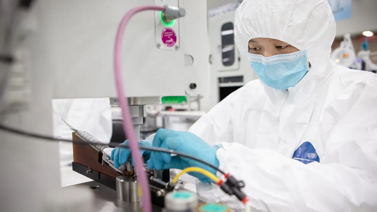 A Getinge technician assembling a heart assist device in a cleanroom