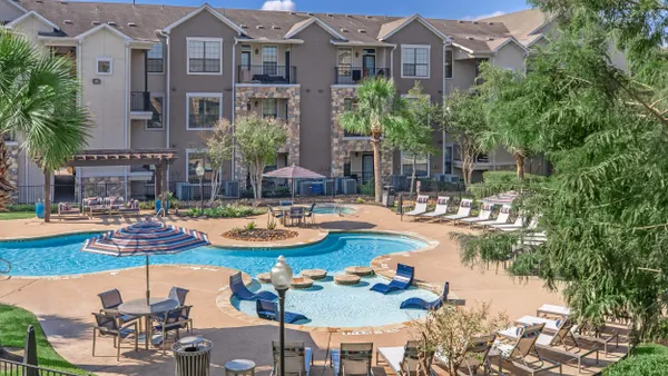 Garden-apartment community surrounded by swimming pool.