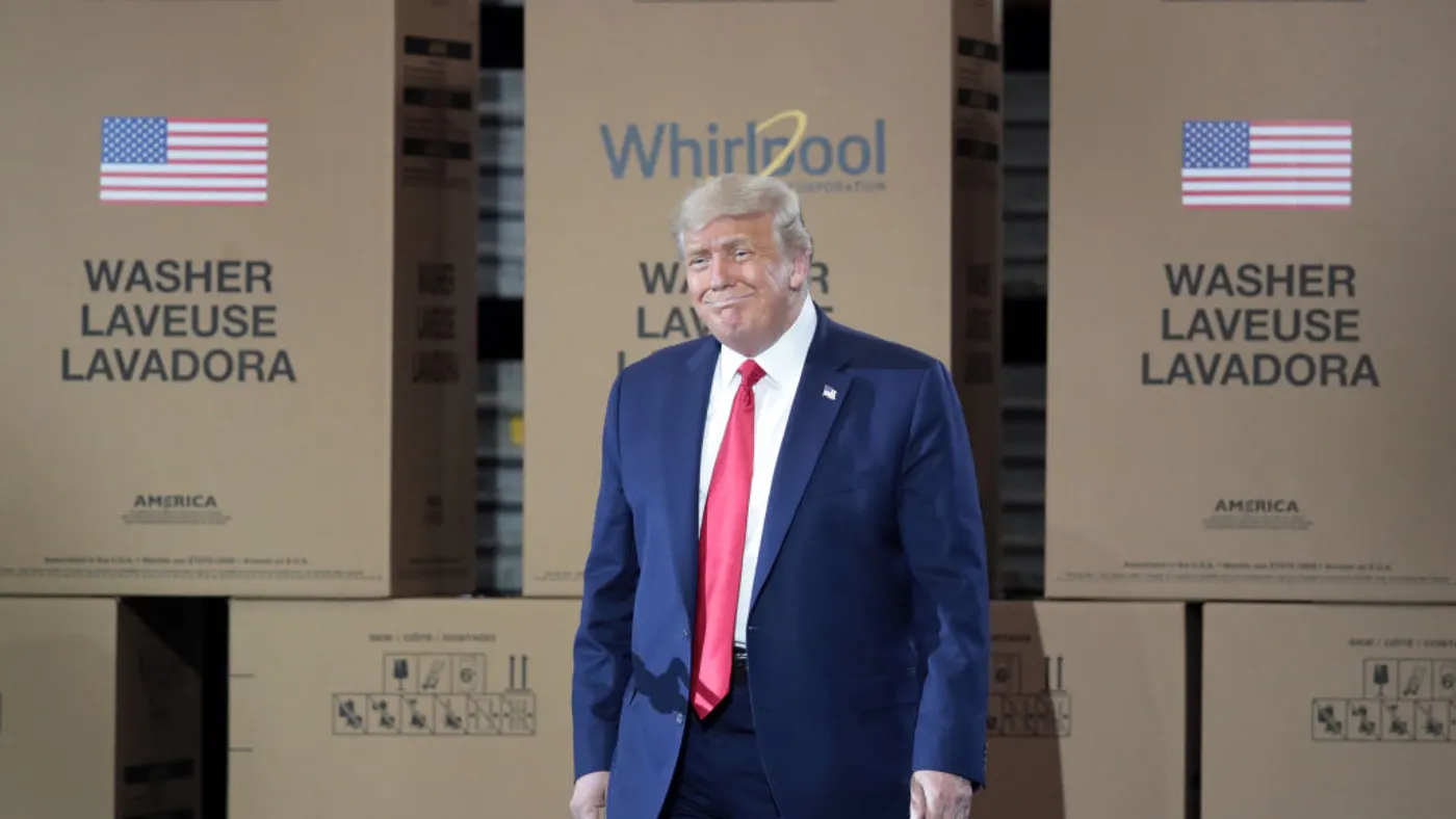 Donald Trump stands in front of cardboard boxes at a Whirlpool factory.