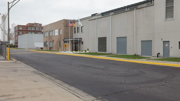 The outside of an industrial facility with flags in front.