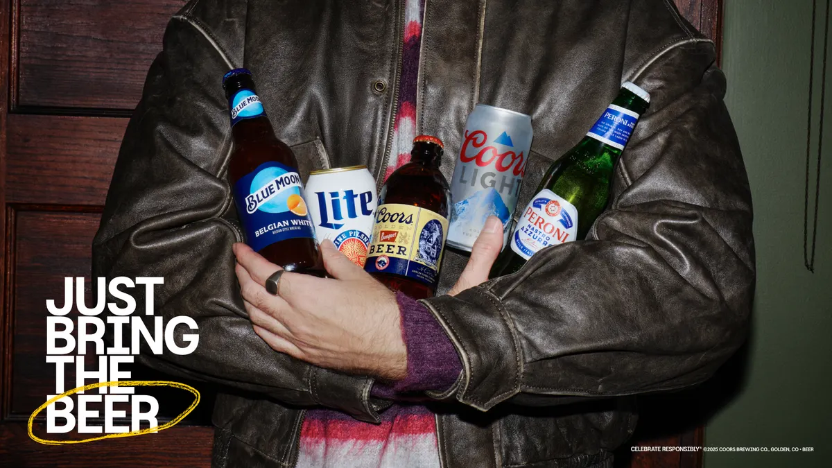 A person in a leather jacket holds an assortment of Molson Coors products.