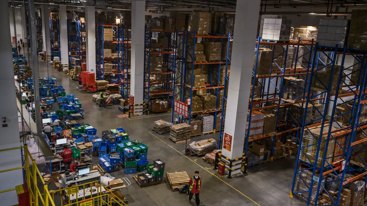 Workers from JD.com work in the warehouse at the company's main logistics hub during an organized tour for Singles Day on November 11, 2020