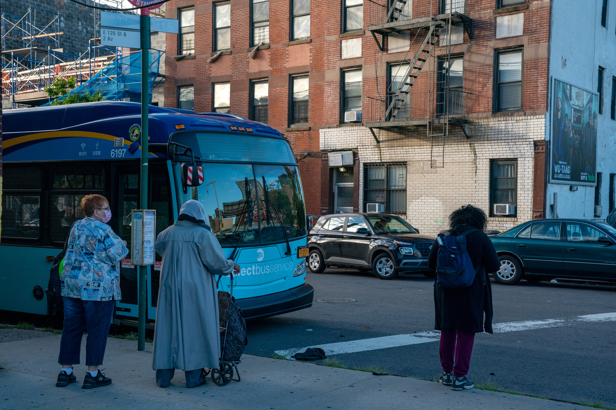 People wait for a bus in New York City. 