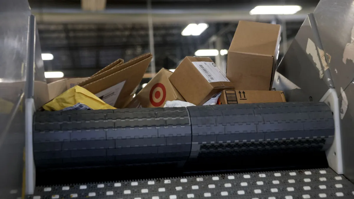 Packages roll along a conveyor belt.