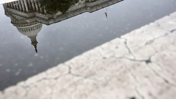 The US Capitol is reflected upside down in a cracked Washington, D.C. road