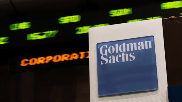 A stock ticker scrolls behind a Goldman Sachs banner at the stock exchange