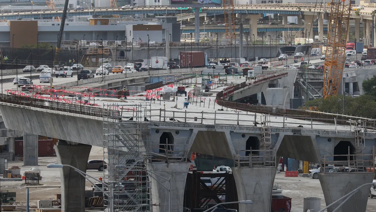 Construction workers build the “Signature Bridge,” replacing and improving a busy highway intersection at I-95 and I-395 on March 17, 2021 in Miami, Florida.